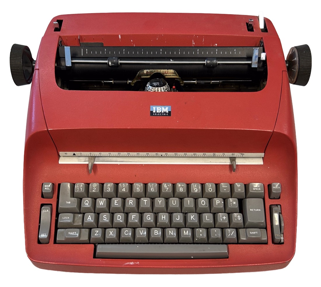 A red IBM Selectric typewriter, seen from the front